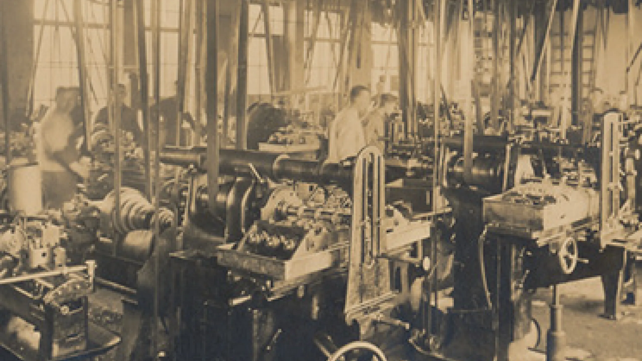Eine Halle aus dem Jahr 1925 voller Maschinen und einigen Arbeitern.